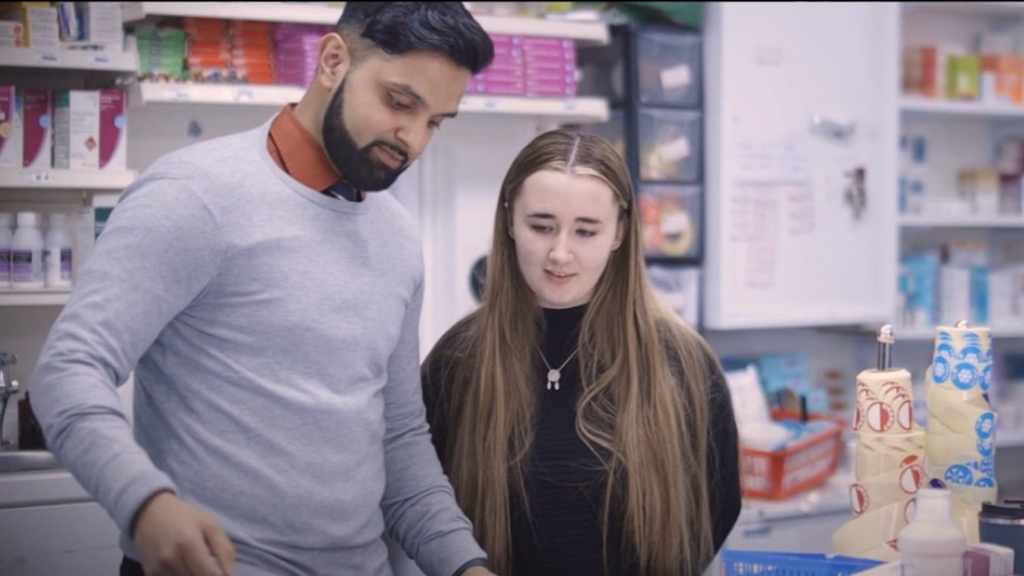 Image of pharmacist working with health student