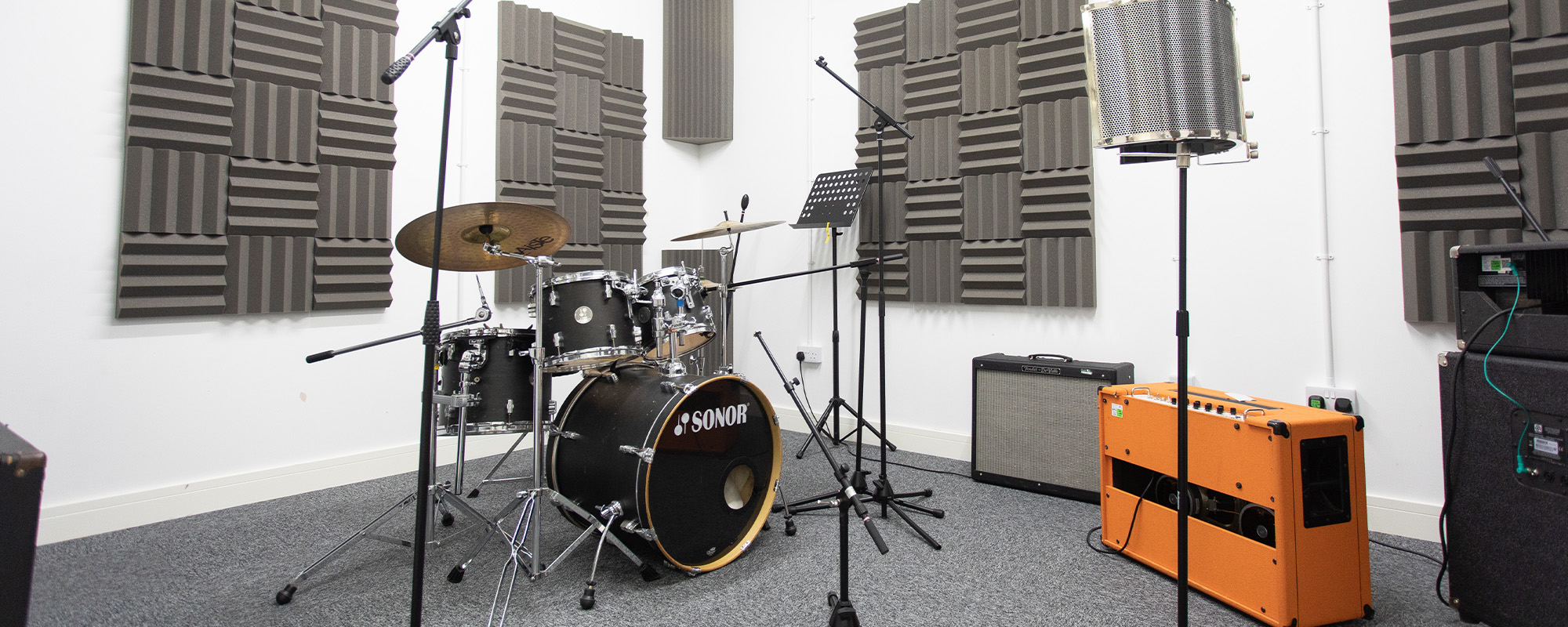 Photo of a rehearsal room with a drum kit in place