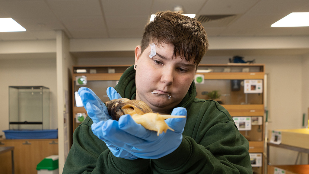 Student holding a large snail