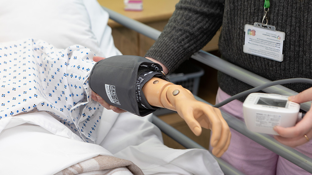 Student demonstrating how to take blood pressure 