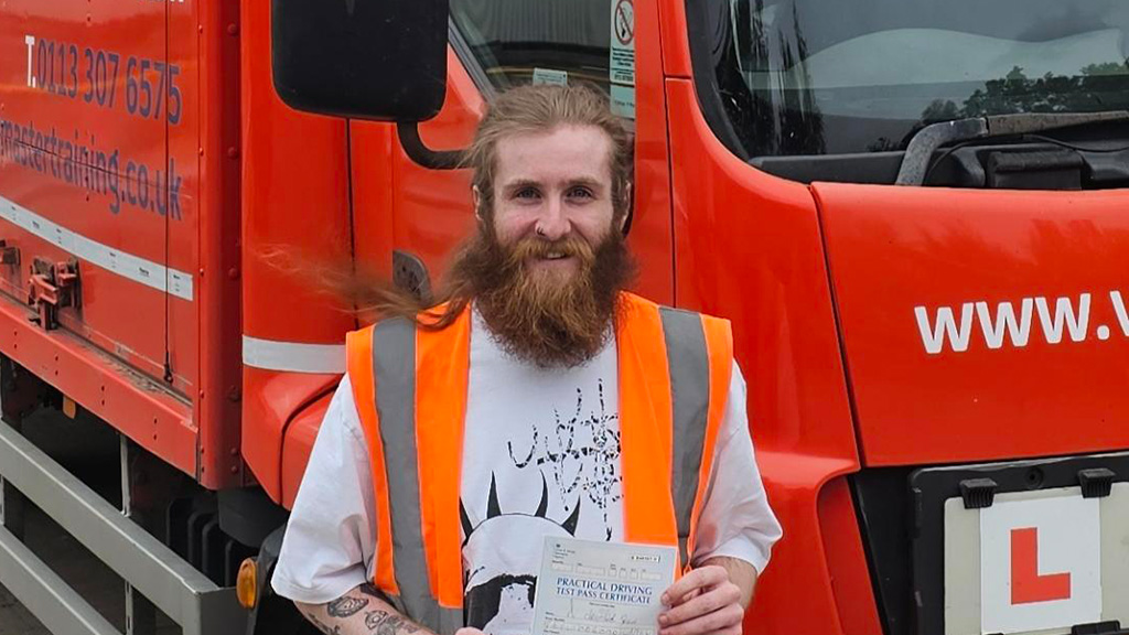 Photo of student holding driving test pass certificate