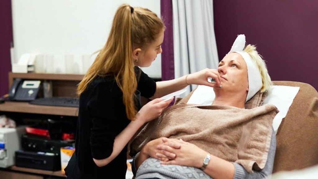 Student applying a facial treatment