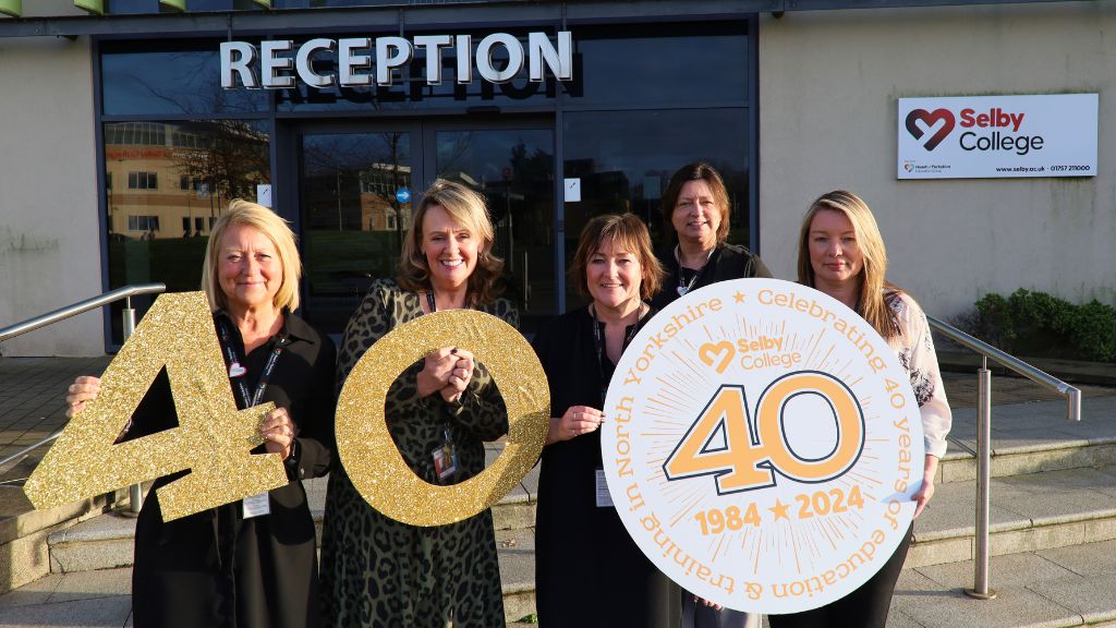 Selby College’s Executive Team holding 40th Anniversary signs