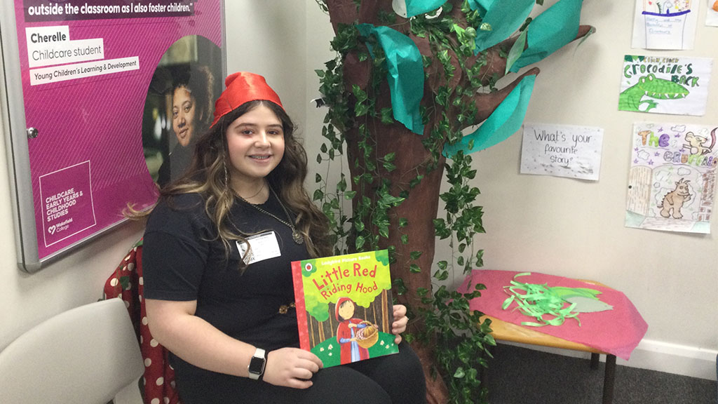 Childcare student dressed as red riding hood holding the book