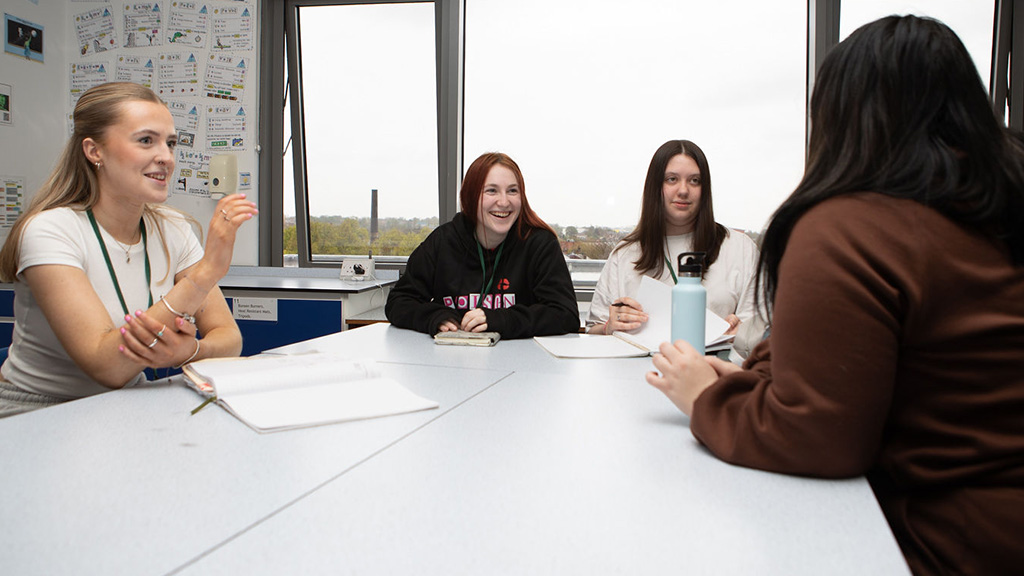 Students talking around a desk