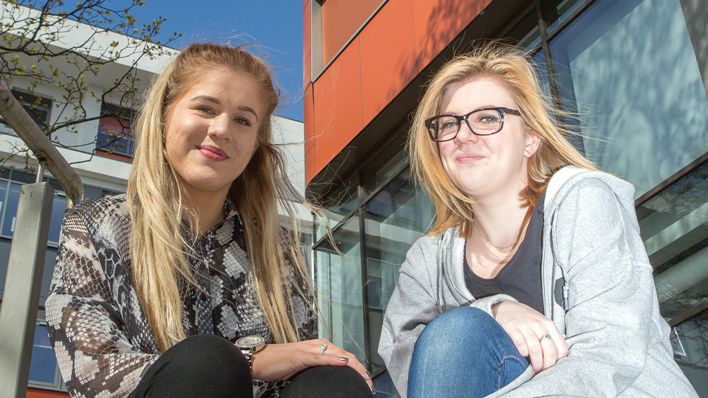 Two sitting outside Wakefield College