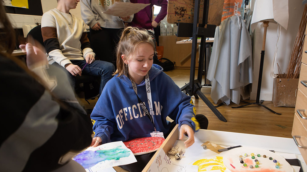 Student looking through their art work