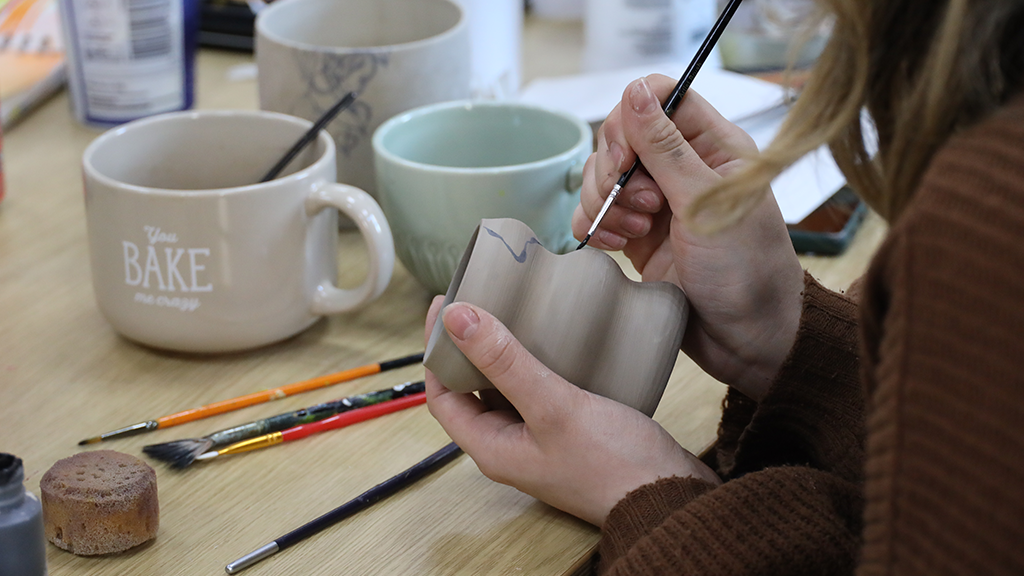 Student painting on ceramics