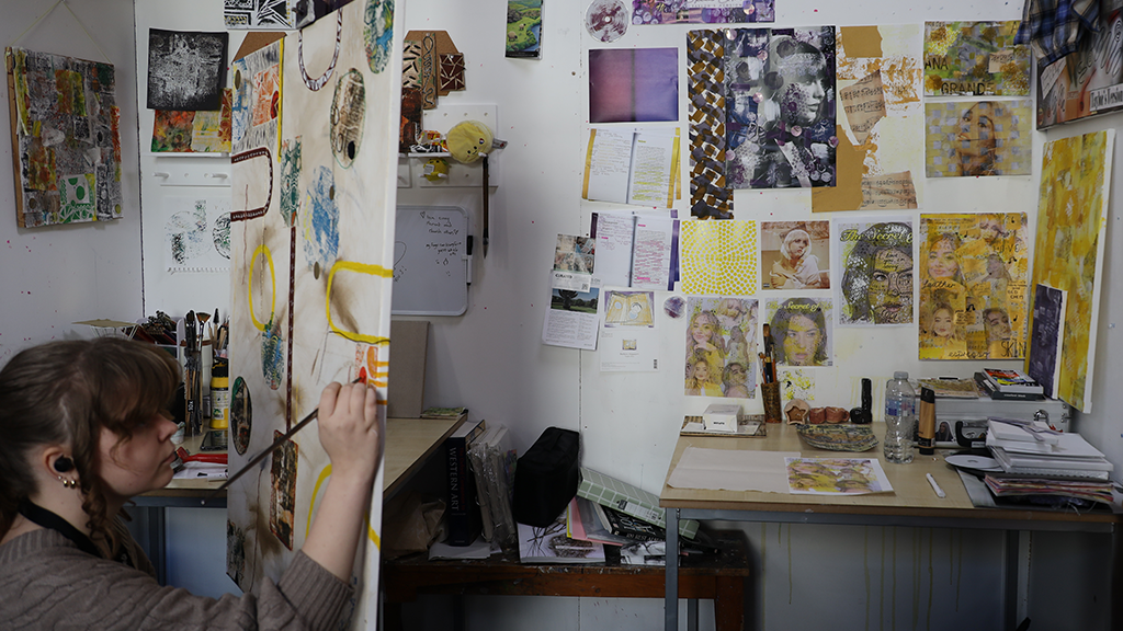 Student painting in an art studio