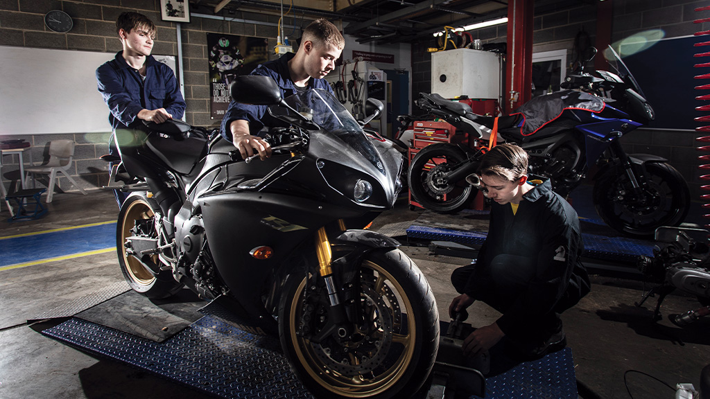 Students working on motorbike in workshop