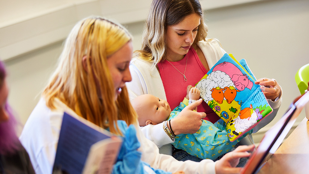 Childcare students with fake baby