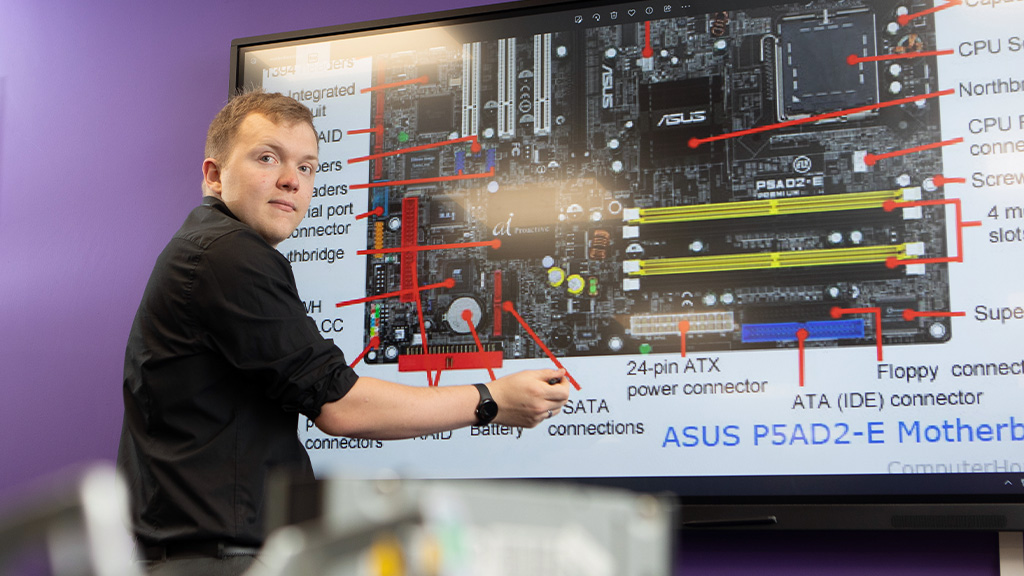 Student pointing to a large digital screen