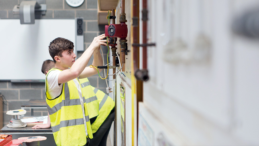 Student learning in plumbing workshop