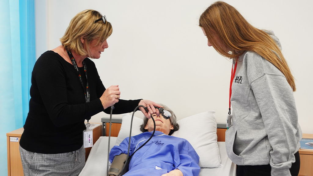 Healthcare student and tutors working in mock hospital