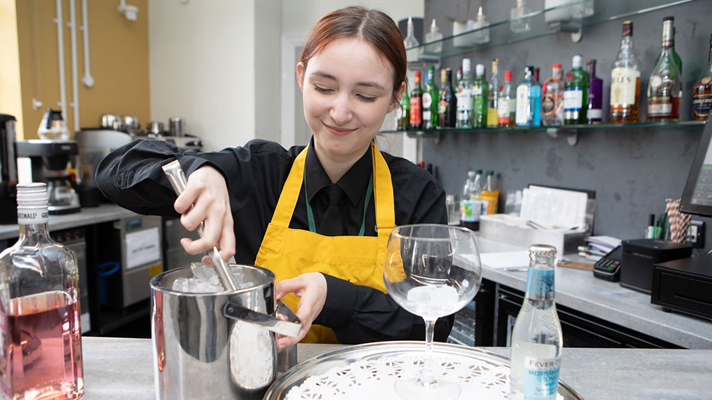 Student serving drinks at the bar