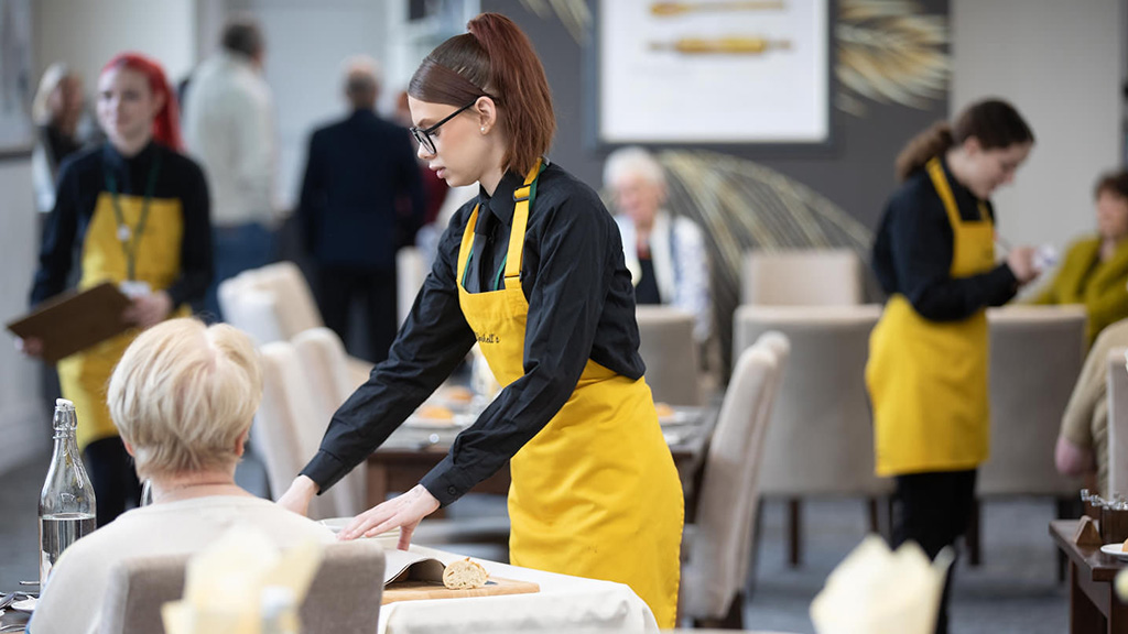 Student serving customers in the restauraunt