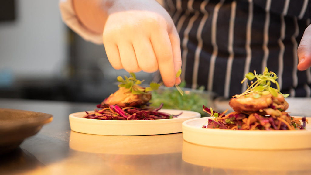 Catering student preparing a dish 