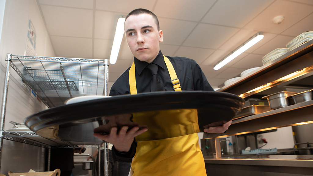 Student carrying a serving tray with food