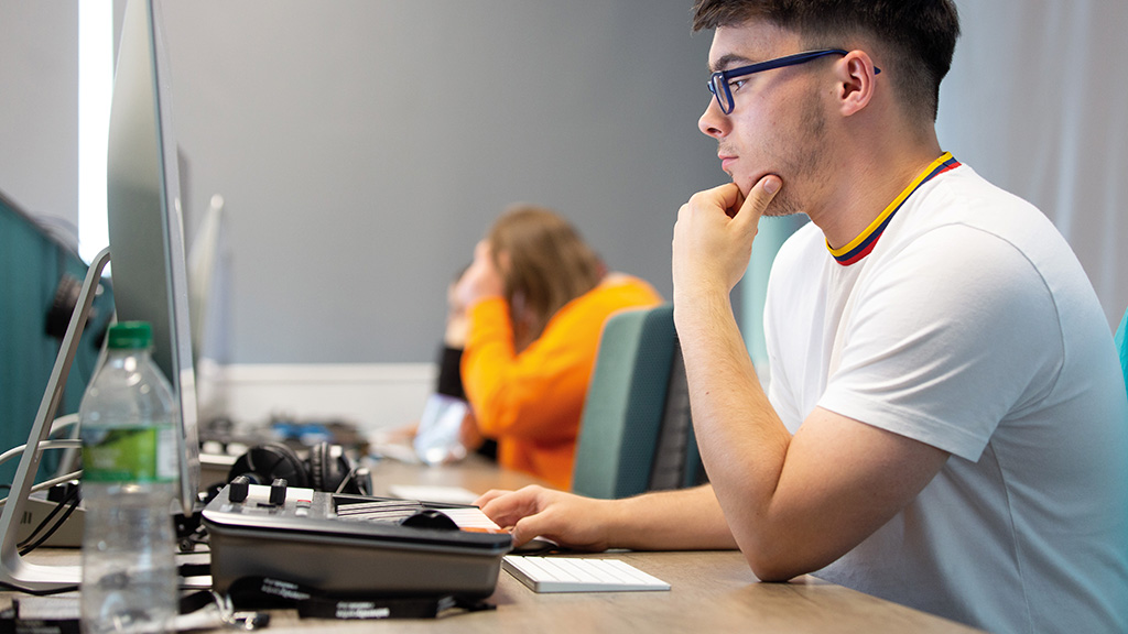 Student working on a music mixing desk