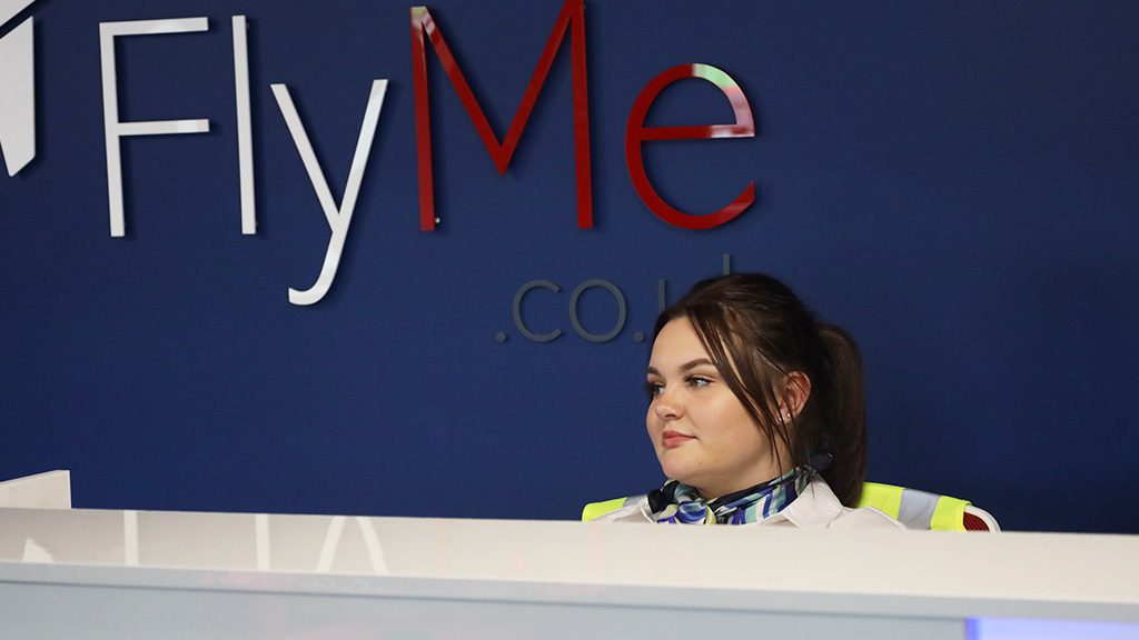 Student sitting behind an airline departure desk